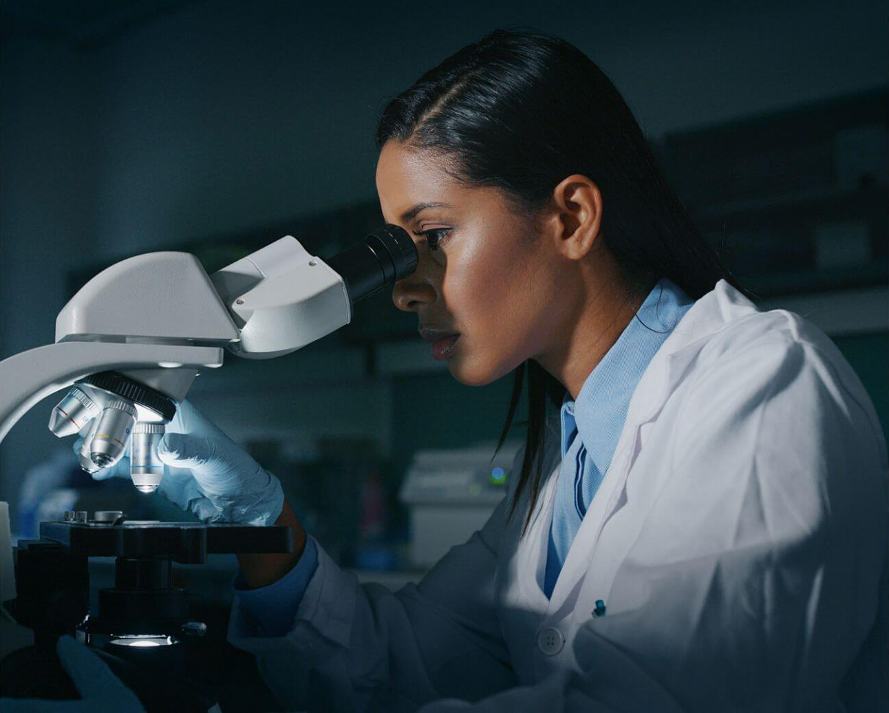 scientist looking through microscope